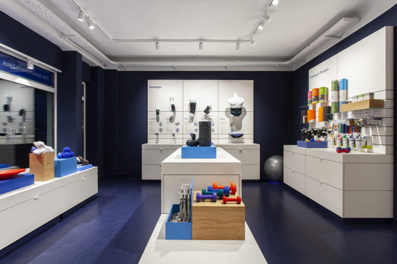 SEEGER醫療用品商店空間設計，地板墻壁的深藍色與純白色家具形成鮮明對比