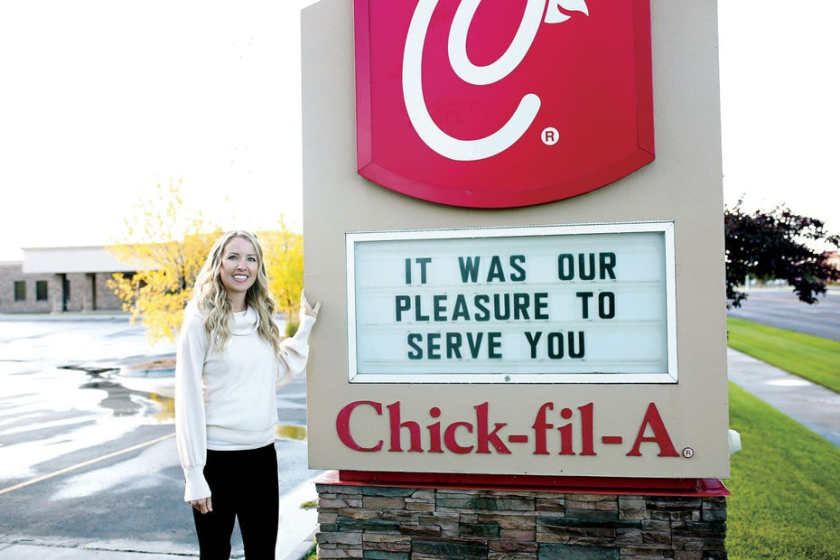  圖：一個女人站在 Chick Fil A 標志旁邊的照片